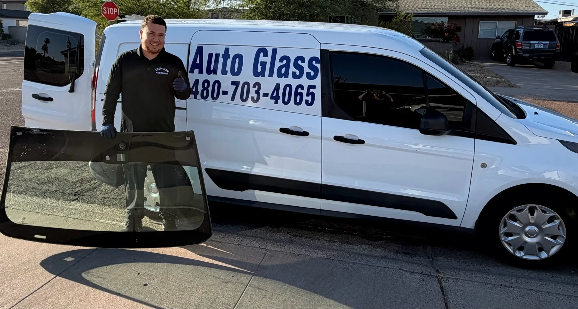 New Gen Auto Glass technician with windshield next to service van