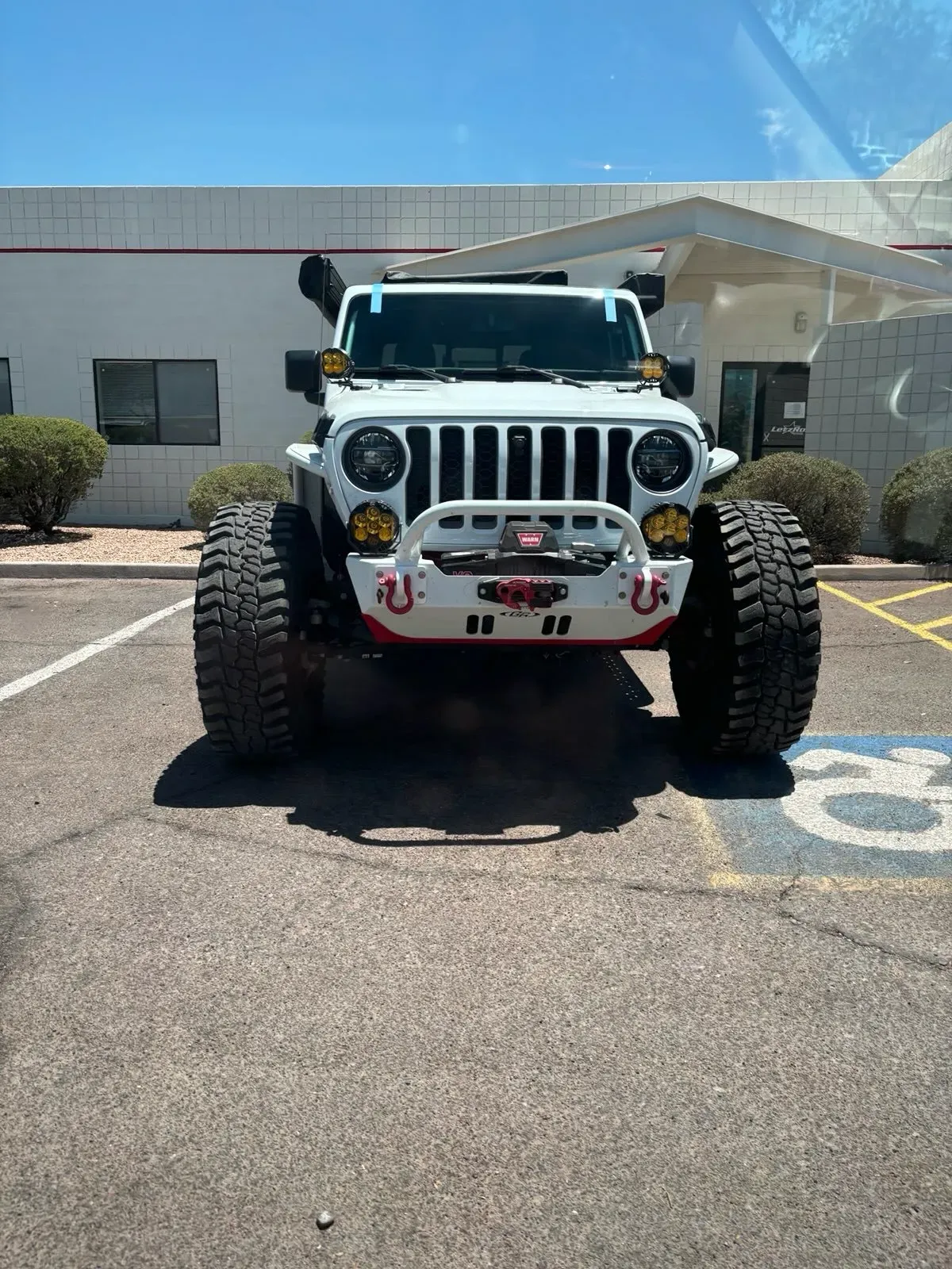 Windshield replacement on lifted white Jeep Wrangler