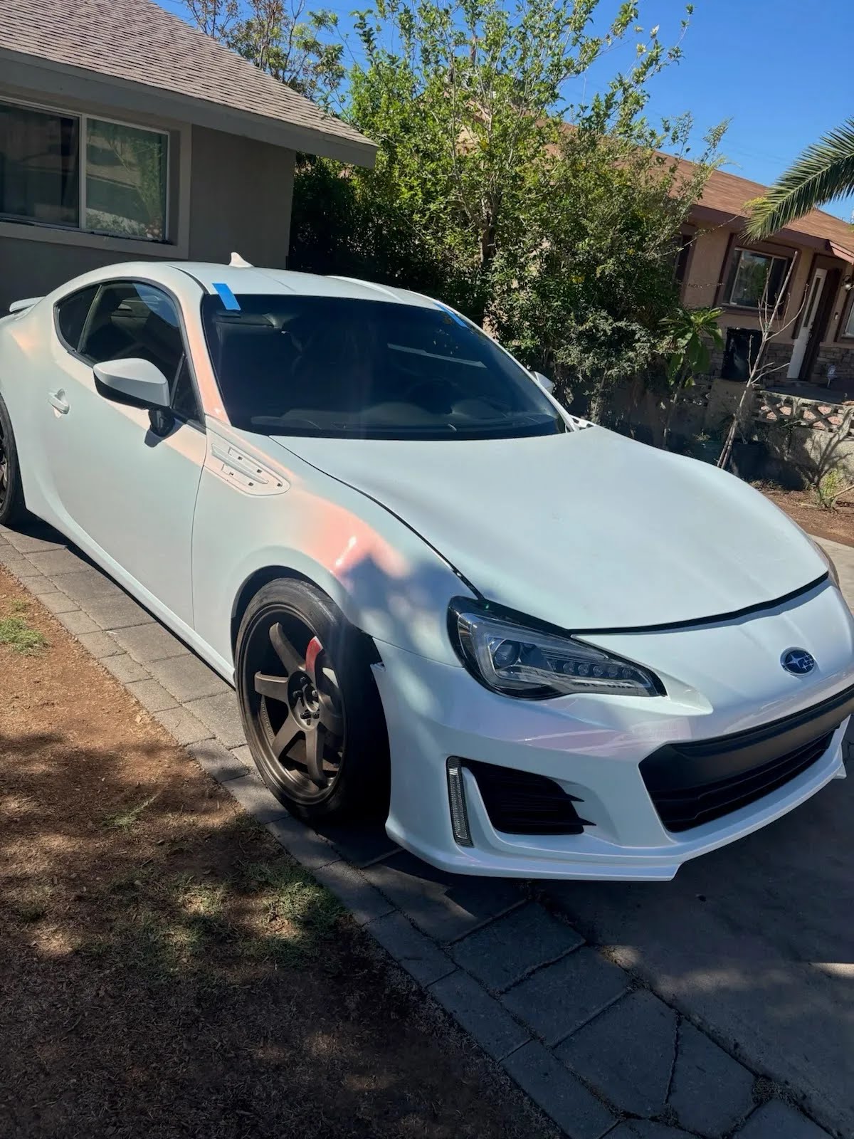 White Subaru BRZ after windshield service at a home